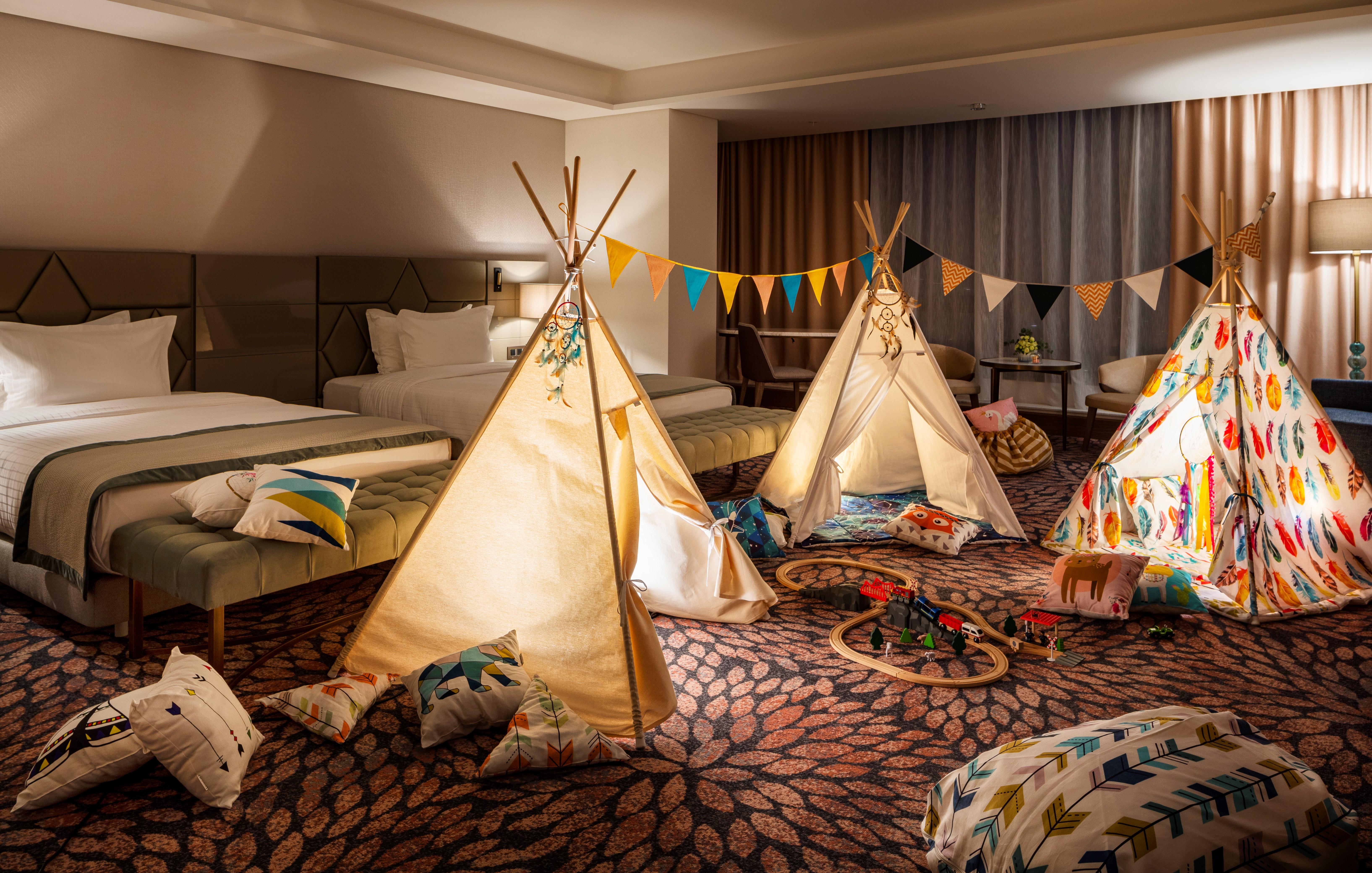 Grand Hotel Millennium โซเฟีย ภายนอก รูปภาพ The photo shows a cozy room featuring three children's teepees made of fabric, arranged in a playful manner. The teepees are decorated with colorful patterns and surrounded by various cushions and pillows scattered on the floor. There are also decora